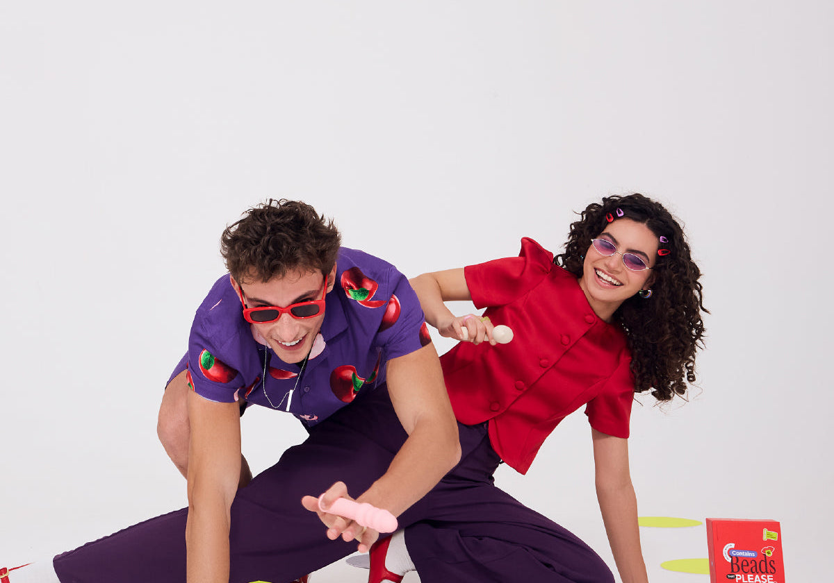 Couple holding body-safe silicone vibrators on a plain background