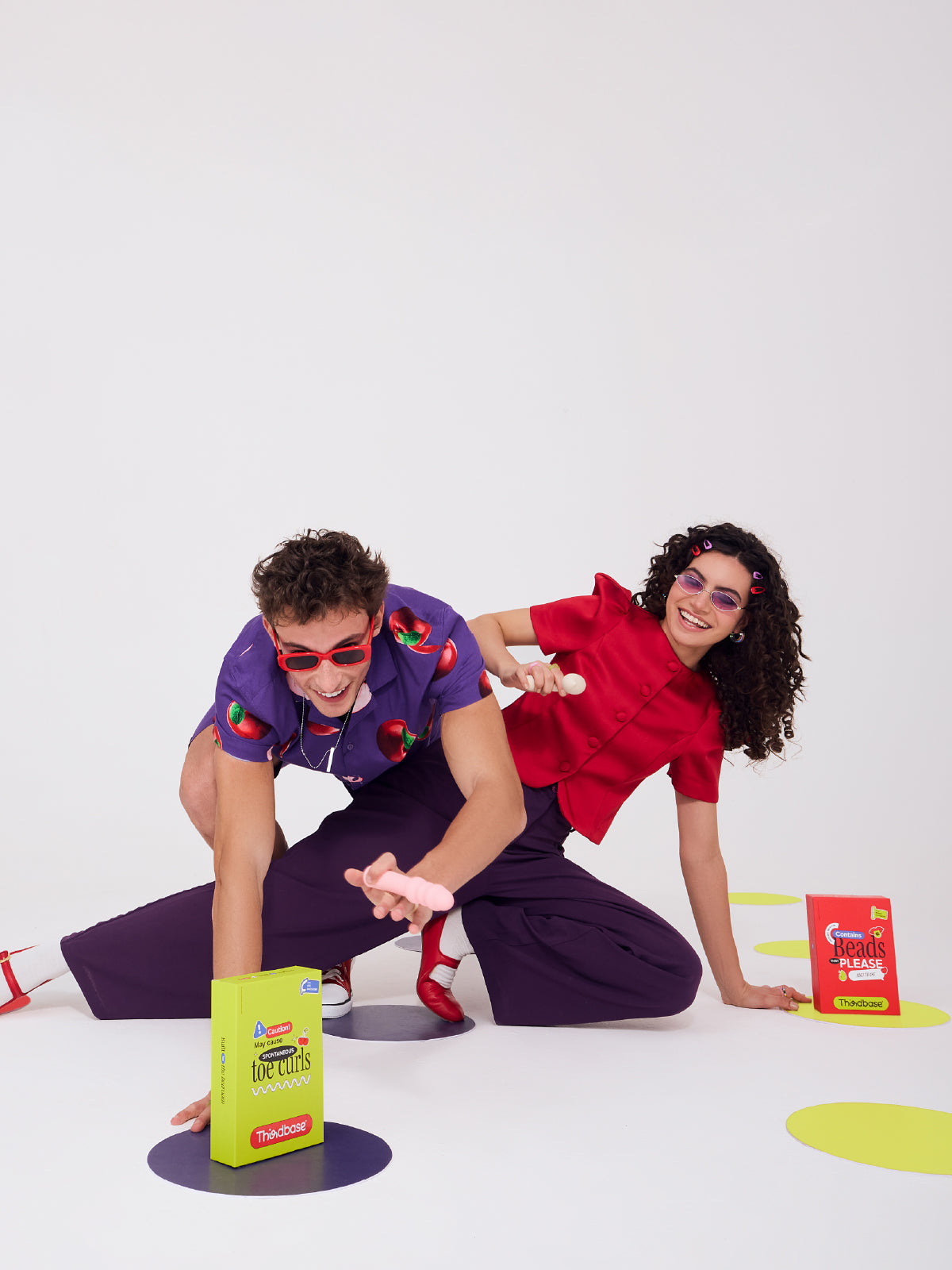 Couple holding body-safe silicone vibrators on a plain background