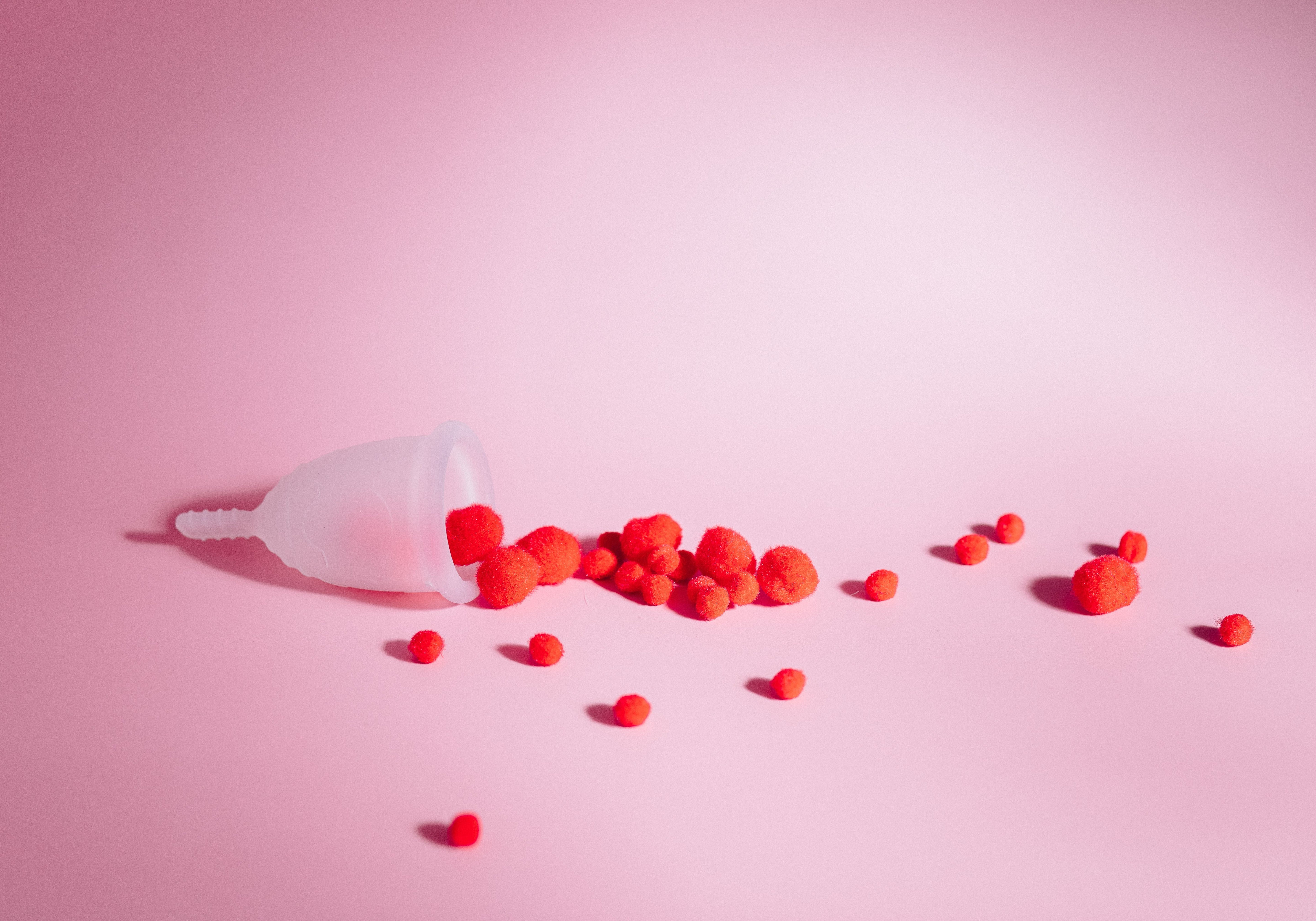 A period tampon on a plain pink surface